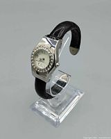 Three-quarter view of the wristwatch on stand showing case, bezel and strap