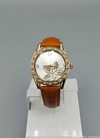 Front view of watch on stand showing dial, bezel, and strap