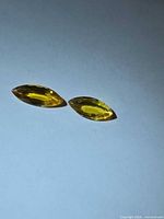 Both yellow marquise sapphires on white background