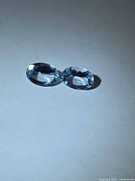 Both aquamarines side by side showing color and cut