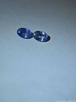 Pair of oval blue sapphires on neutral background