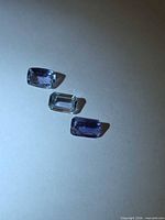 Three Tanzanite gemstones arranged in line showing cuts and color
