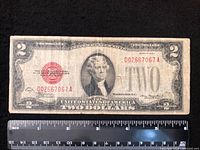 Obverse of 1928D $2 red seal note with ruler for scale