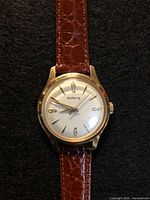Front view of Volkswagen Wolfsburg gold-tone wristwatch showing dial and strap