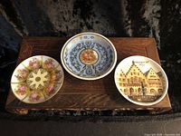 Front view of all three plates on wooden stand