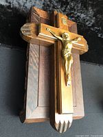 Front view of crucifix showing brass corpus on wood cross and box base