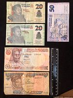 All five Nigerian banknotes displayed with ruler for scale