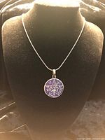 Pendant on display bust with chain for scale