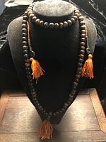 Full length of bone mala on display bust showing tassels and counter beads