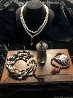 Group shot of all six items on display bust and wooden base