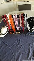 Overall view of necklaces on display stand and earring pairs on table