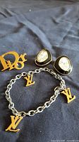 Overview of Dior pin, earrings and YVL bracelet