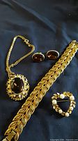 Full lot: bracelet, necklace, earrings, brooch on dark background