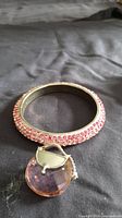 Pavé pink crystal bangle and faceted crystal brooch displayed together