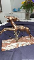Full view of bronze-tone gazelle on marble base