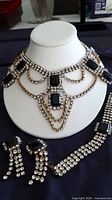 Full parure on display bust showing necklace, bracelet, earrings