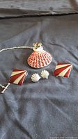 Group view showing pendant necklace, enamel earrings, shell stud earrings
