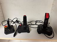 Three DE-9 joysticks side by side showing overall design and cords