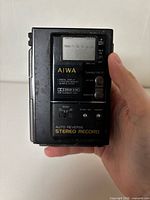 Front view showing Aiwa branding, LCD display, control buttons and Auto Reverse Stereo Record text