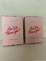 Front view of two boxed passport holders