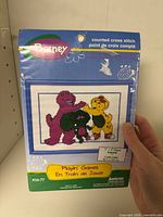 Front of sealed Barney counted cross stitch kit showing design, brand, size, series and package wear