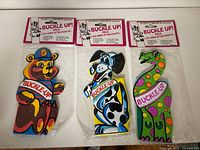 Front view of all three packaged Buckle Up Pals