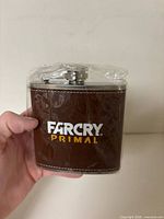 Front view of flask showing Far Cry Primal logo and brown faux-leather wrap