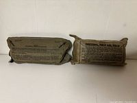 Front view of two sealed field dressings showing size and color