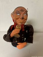 Front view of figurine holding wine glass