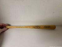Full view of wooden miniature bat showing overall size and finish