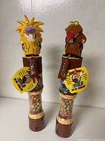 Front view of both Norbert and Daggett Giggle Stick dispensers showing full height and candy tubes