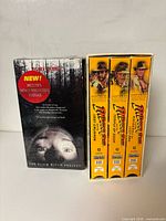 Front view of sealed Blair Witch Project VHS beside three Indiana Jones tapes in box