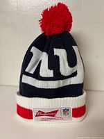 Front view showing NY logo, Budweiser and NFL patches, red pom