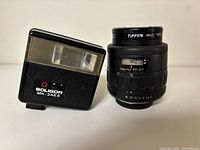Front view of Pentax 35-80 mm lens with Tiffen filter beside Soligor MK-3AES flash