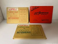 All three Autobridge sets: red Deluxe box, two tan envelope sets