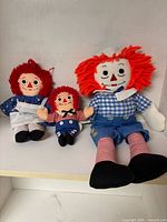 Group view of all three Raggedy Ann & Andy dolls showing relative sizes and clothing