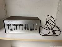 Front and top view of equalizer showing sliders, controls and power cord