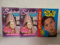 Front covers of two Sabrina The Troll Bride books and Malcolm In The Middle Life Is Unfair book