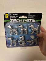 Front view of sealed Tech Pets blister pack showing six silver robot dog figures