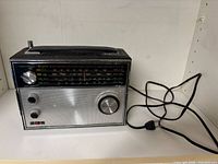 Front view of Realistic Astronaut 4 radio showing overall form, speaker grille, tuning dial and AC cord