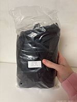 sealed plastic bag containing folded black cover