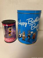 Tin and figurine together showing scale