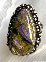 Front view of ring showing teardrop atlantisite cabochon and beaded bezel