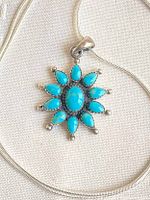 Necklace laid flat showing pendant front and snake chain