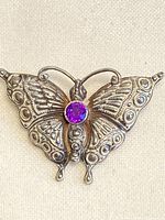 Front view of butterfly brooch showing amethyst and silver detailing