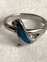Front view of sterling silver ring showing dinosaur motif with turquoise inset