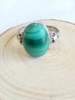 Front view showing oval malachite stone and silver floral accents