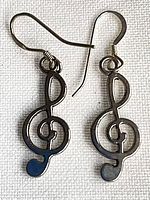 Front view of both sterling silver treble clef earrings with hooks