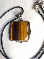 Front view of square tiger eye pendant on cord necklace