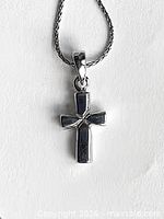 Close-up of sterling silver cross pendant on chain